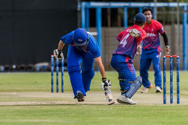 Nepal, in red and blue, claimed a one wicket win over hosts Namibia, in blue, in their opening match in the World Cricket League Division 2. Courtesy Joahn Jooste