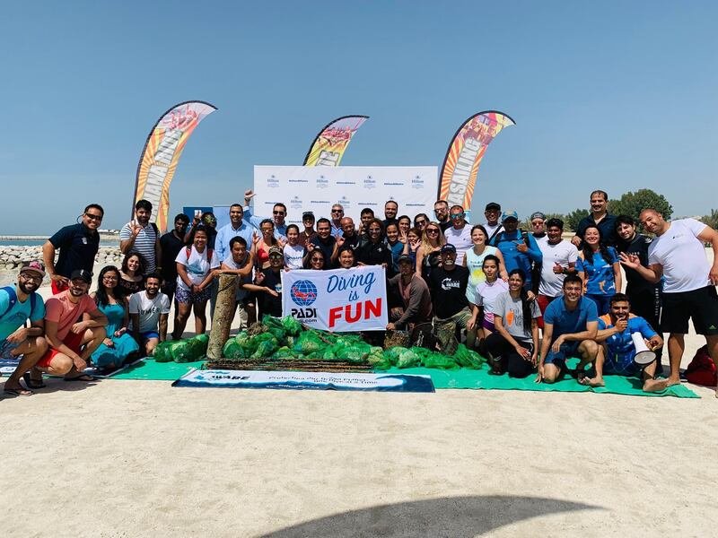 The full group with the debris collected following the dive. Courtesy Hilton Al Hamra Beach