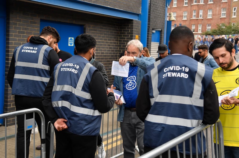 Chelsea fans show vaccine-related paperwork to a Covid-19 steward before entering the club's Stamford Bridge stadium in west London. Reuters