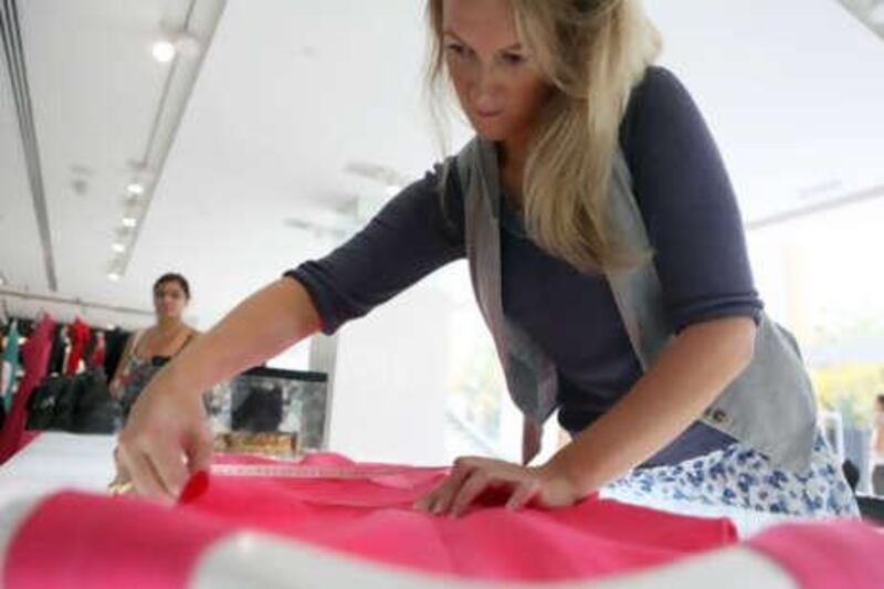 Sophia Money-Coutts measures a dress at Boutique 1 in Dubai. The store carries 150 brands, which makes stocking things in appropriate sizes for its customers a challenge.