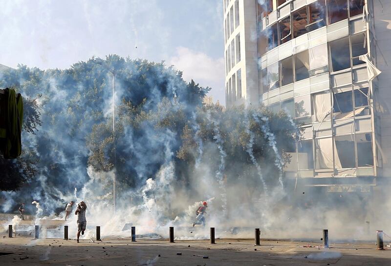 Demonstrators run to take cover from tear gas fired by police. Reuters