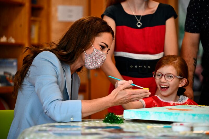 Kate puts a hand print on a canvas during the visit to East Anglia's Children's Hospice. AP 