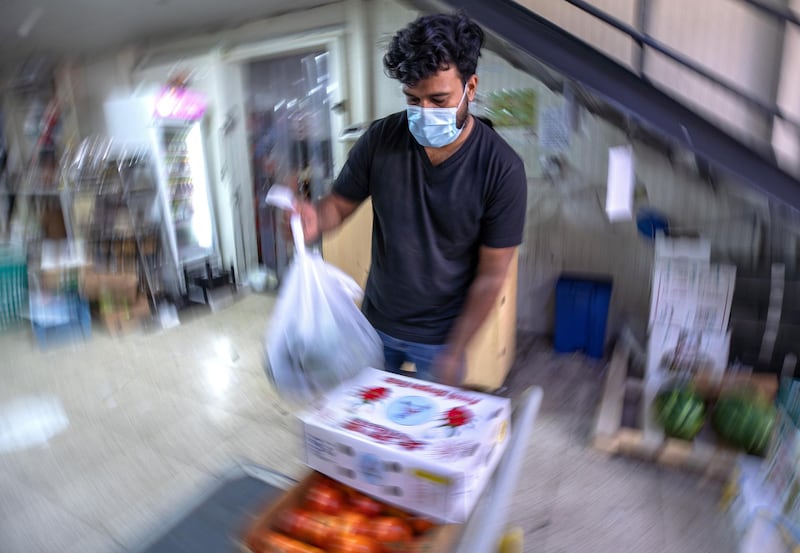 April 26, 2021. A salesman packs some fruit bags at the Abdulla Hassan Trading Establishment, one of the original fruits and vegetable shops in Abu Dhabi which was opened in 1970. Victor Besa / The National.
Section: News/Standalone