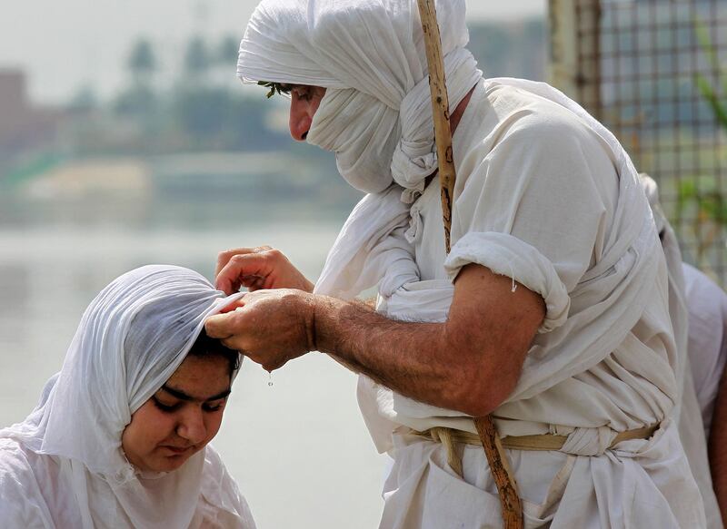 An Iraqi Mandaean cleric baptises a girl on the banks of the Tigris in Baghdad. AFP