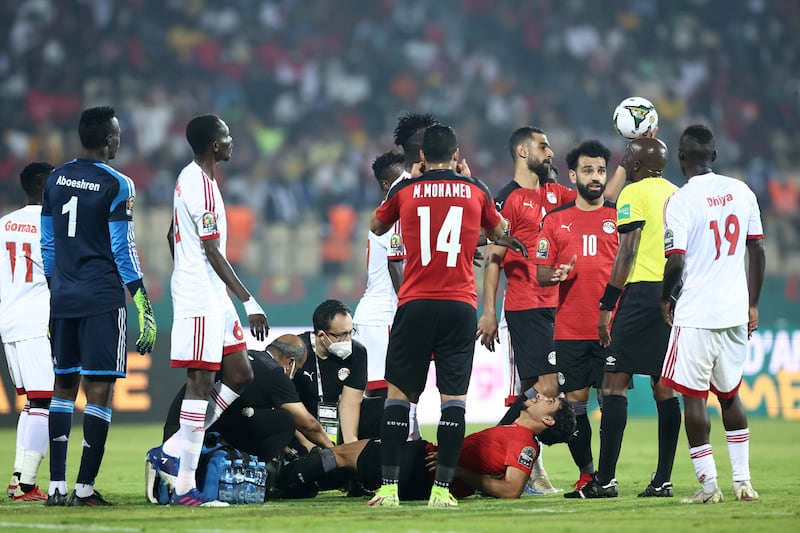 Egypt forward Omar Marmoush lies on the pitch, surrounded by teammates. AFP