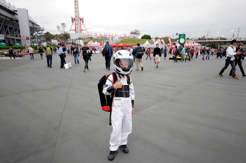 A fan poses for a photo as he arrives before the first practice round of the Formula One Japanese Grand Prix. Kiyoshi Ota / AFP Photo.