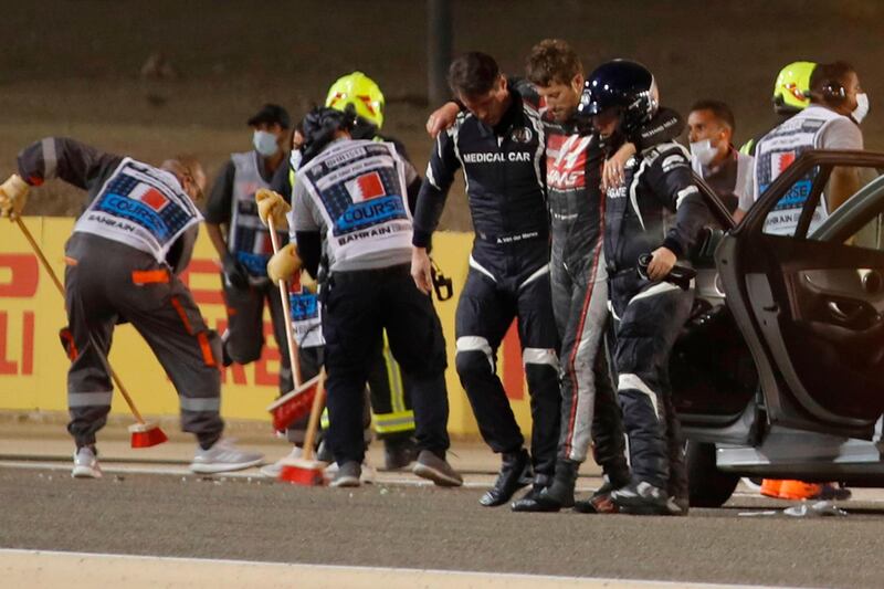 Stewards and medics attend to French driver Romain Grosjean at the Bahrain International Circuit. AFP