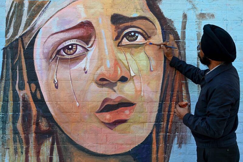 An artist paints a mural during a competition in Amritsar, India. AFP