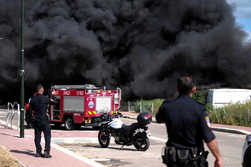 Israeli policemen stand near a fire caused by rockets fired from Lebanon, in Bezet. Reuters