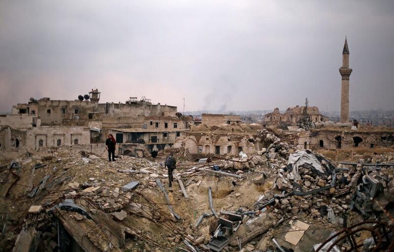 A member of forces loyal to Syria's President Bashar al-Assad stands with a civilian on the rubble of the Carlton Hotel, in the government controlled area of Aleppo. Omar Sanadiki / Reuters