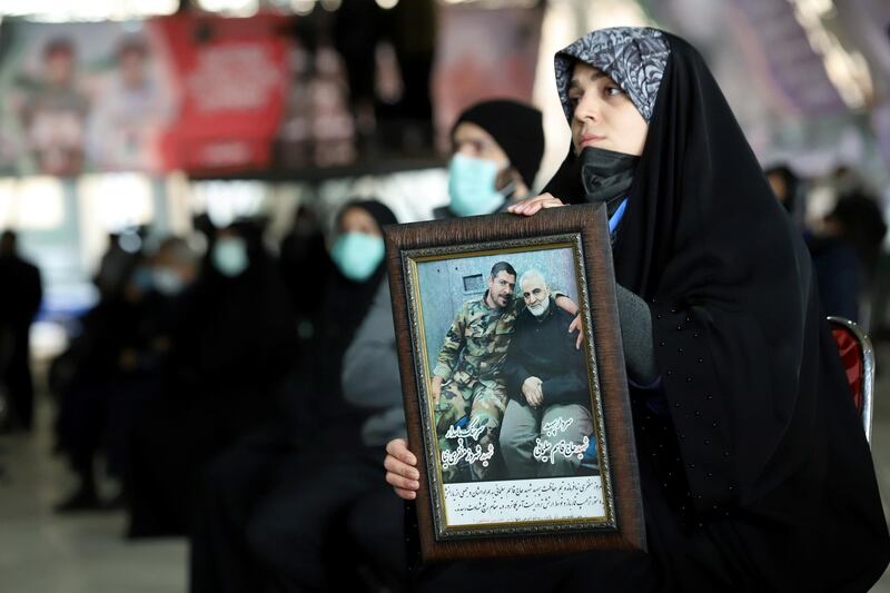 An Iranian woman holds a picture of Qassem Suleimani during the commemoration ceremony in Tehran, Iran January 1, 2021. West Asia News Agency via Reuters