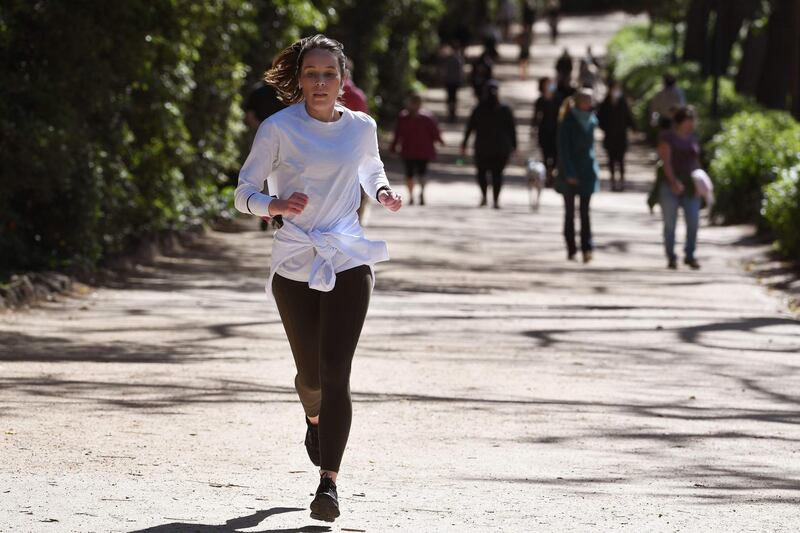 A woman jogs around The Tan running track in Melbourne on September 27, 2020 as an overnight curfew in Australia's second-biggest city will be lifted from September 28, almost two months after it was imposed to counter a surging COVID-19 coronavirus outbreak. / AFP / William WEST
