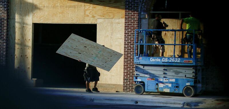 People put plywood up on the windows of a theatre before the arrival of Hurricane Florence in Greenville, North Carolina. Reuters