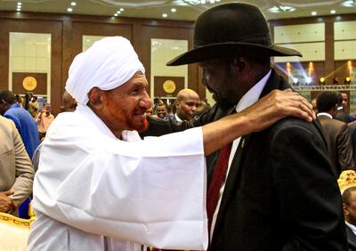 Sudan's veteran opposition leader Sadiq al-Mahdi (L) pats the shoulder of South Sudan President Salva Kiir Mayardit (R) during a ceremony to sign a "constitutional declaration" that paves the way for a Sudanese transition to civilian rule, in the capital Khartoum on August 17, 2019. The agreement was signed by Mohamed Hamdan Daglo, deputy chief of the military council, and Ahmed al-Rabie, representing the Alliance for Freedom and Change protest umbrella group, an AFP reporter said. Heads of state, prime ministers and dignitaries from several countries attended the ceremony in Khartoum. / AFP / Ebrahim HAMID
