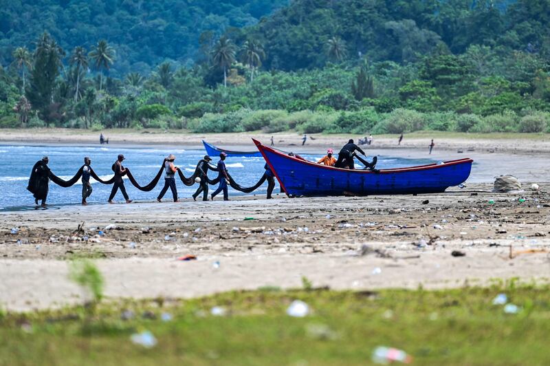 Fishermen load their nets at a beach in Lhoong, Indonesia's Aceh province. AFP