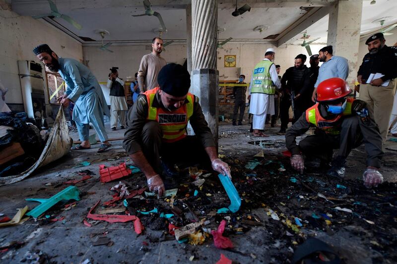 Security officials examine the site of a blast at a religious school in Peshawar. AFP