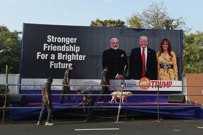 Gujarat police's bomb detection disposal squad officials along with a sniffer dog inspect a stage displaying pictures of India's Prime Minister Narendra Modi, US President Donald Trump and First Lady Melania Trump, on the outskirts of Ahmedabad, ahead of Trump's visit to India.  AFP