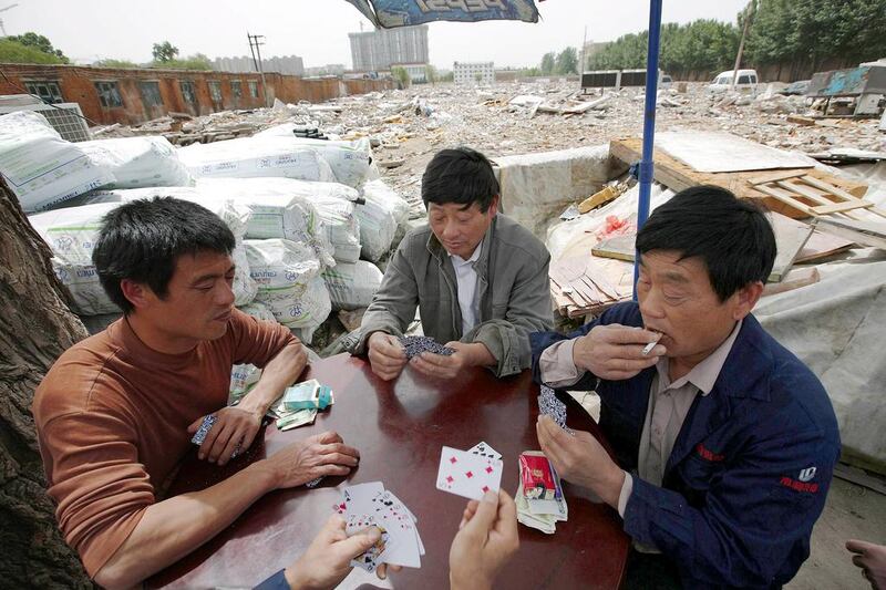 Recycling workers play poker in Dongxiaokou village. Kim Kyung-Hoon / Reuters