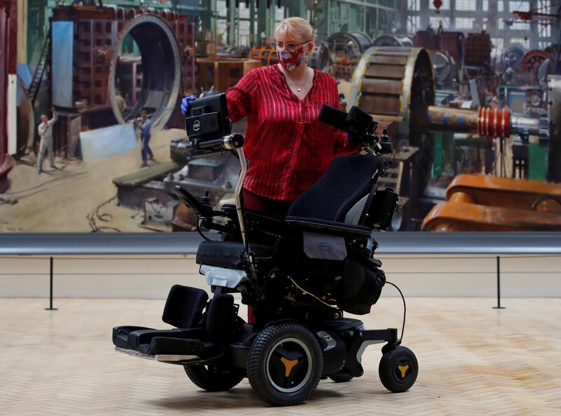 Kate Perks, senior collections care conservator at London's Science Museum, with the wheelchair of Prof Stephen Hawking. Reuters