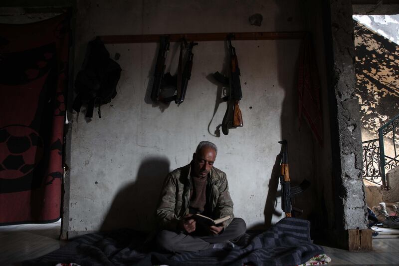 A Syrian rebel fighter from the National Liberation Front reads in the al-Rashedin area west of Aleppo. AFP