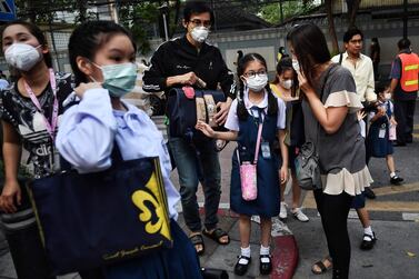 Parents bring their children to school wearing protective face masks in Bangkok, Thailand, on February 3, 2020. AFP
