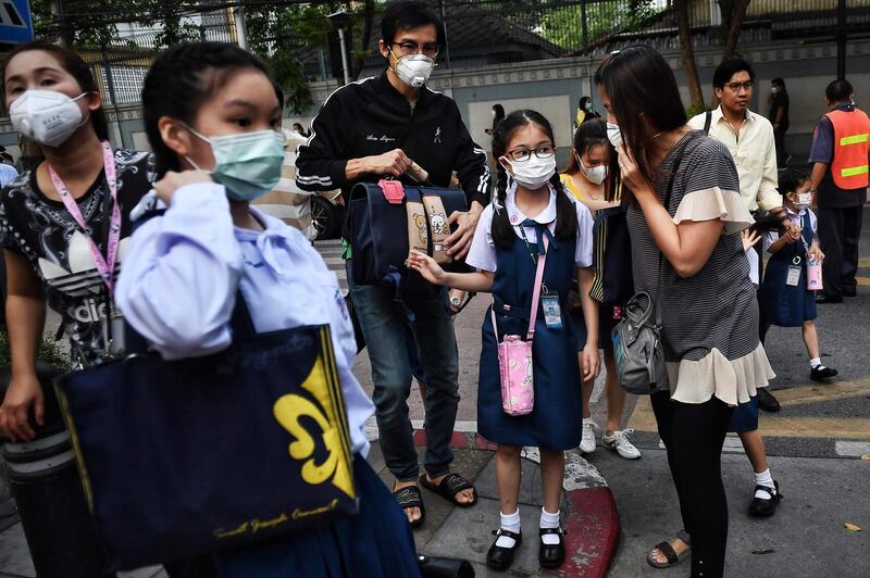 Parents bring their kids to school wearing protective facemasks in Bangkok on February 3, 2020. Thailand so far has detected 19 confirmed cases of the novel coronavirus believed to have originated in the central Chinese city of Wuhan, which is under lockdown. / AFP / Lillian SUWANRUMPHA
