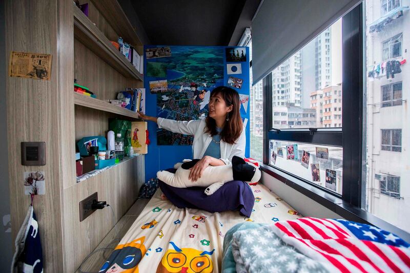 This picture taken on April 28, 2018 shows Jezz Ng sits on her bed where she rents a small living space in a co-sharing building in the Mong Kok district of Hong Kong. As housing prices spiral in Hong Kong, young professionals are living in ever-shrinking spaces, with box-like "nano-flats" and co-shares touted as fashionable solutions. - TO GO WITH AFP STORY: Hong Kong-housing-social-lifestyle-urban-planning, FEATURE Yan ZHAO

 / AFP / ISAAC LAWRENCE / TO GO WITH AFP STORY: Hong Kong-housing-social-lifestyle-urban-planning, FEATURE Yan ZHAO

