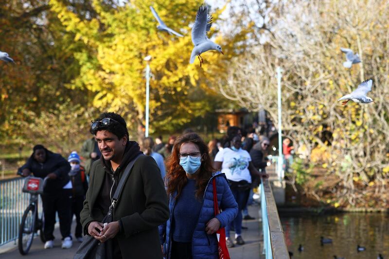 People walk through St James Park in London. Reuters