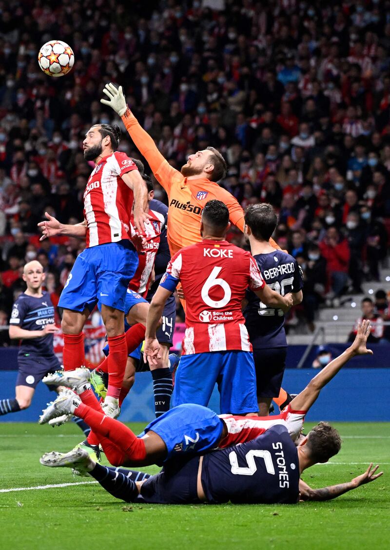 Atletico's Slovenian goalkeeper Jan Oblak jumps to clear the ball. AFP