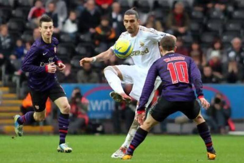 Swansea City's Chico Flores, centre, controls the ball during the FA Cup third-round match against Arsenal. Geoff Caddick / EPA