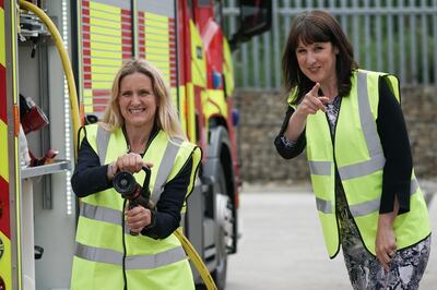 BATLEY, ENGLAND - JUNE 24: Labour candidate for the Batley and Spen by-election Kim Leadbeater (left) and Labour's Shadow Chancellor Rachel Reeves try out a fire hose during a tour of Angloco, a company that makes fire and rescue vehicles, during campaigning on June 24, 2021 in Batley, England. Ms Leadbeater is campaigning for the seat previously held by her sister, Jo Cox, who was murdered in 2016. (Photo by Christopher Furlong/Getty Images)