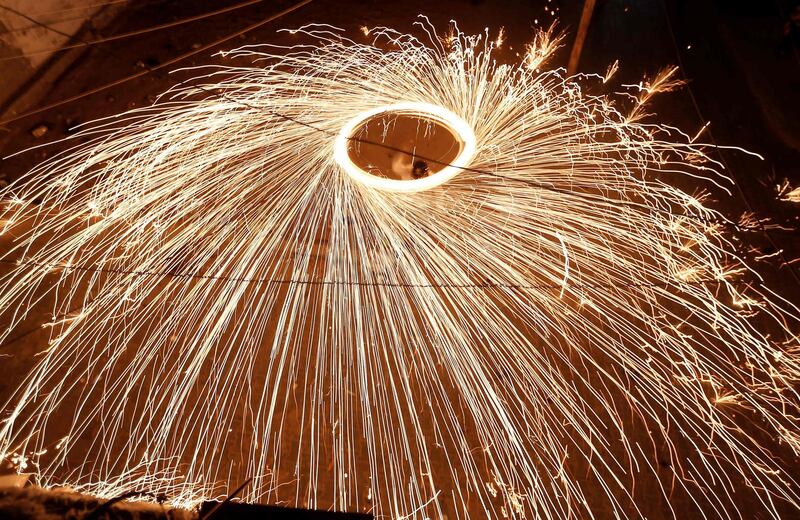 A Palestinian youth swings a homemade fireworks sparkler as people celebrate on the night before the start of Ramadan, in Gaza City. AFP