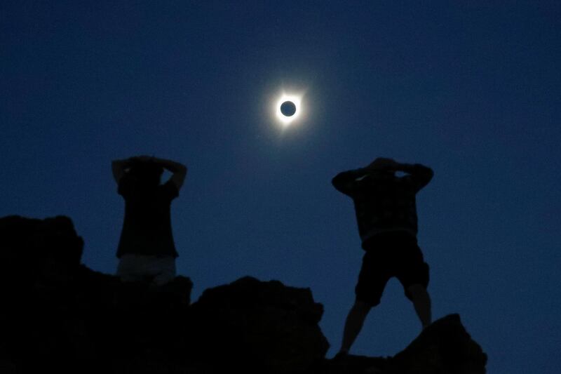 Enthusiasts Tanner Person, right, and Josh Blink, both from Vacaville, California, watch a total solar eclipse while standing atop Carroll Rim Trail at Painted Hills, a unit of the John Day Fossil Beds National Monument, near Mitchell, Oregon, US. Adrees Latif / Reuters