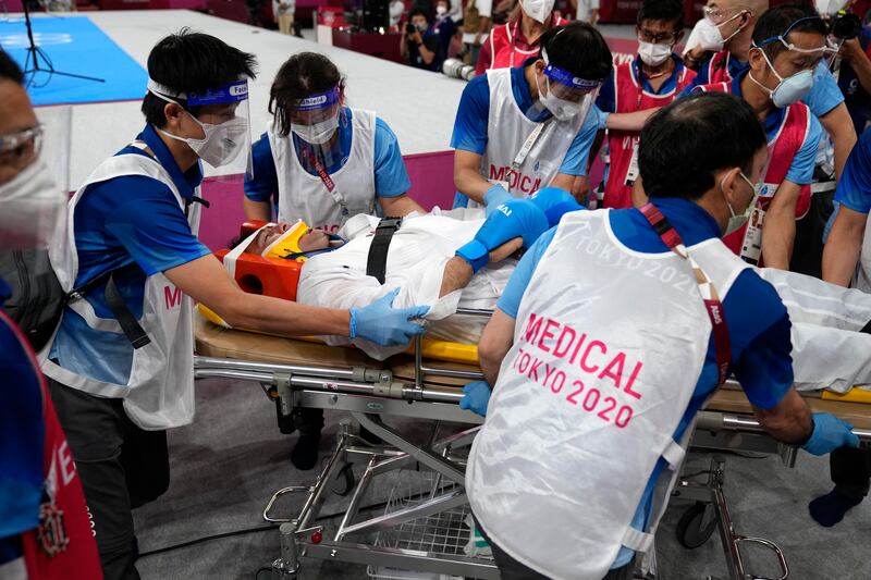 Medical personnel take Sajad Ganjzadeh of Iran away after he was injured while competing against Tareg Hamedi of Saudi Arabia.