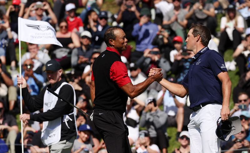Tiger Woods shakes hands with Kramer Hickok on the 18th green. AFP