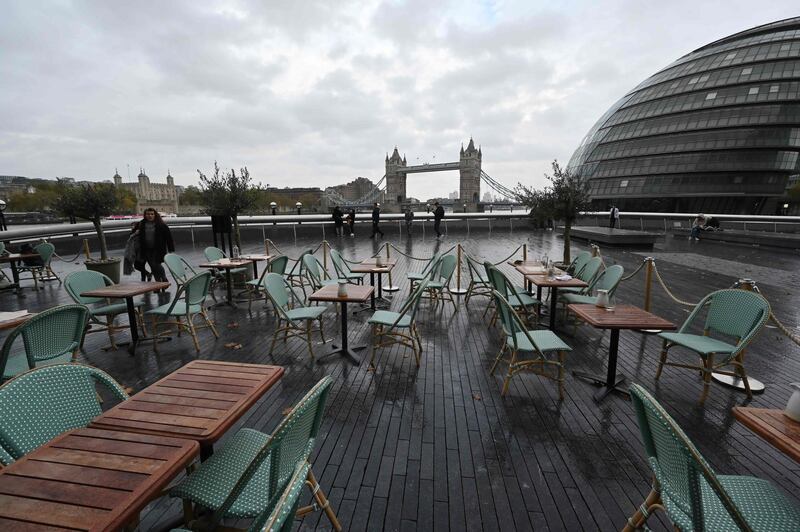 Empty tables are seen outside a restautrant with Tower Bridge in the background in London. A new four-week coronavirus lockdown in England will be extended if it fails to reduce infection rates, the government said Sunday. AFP