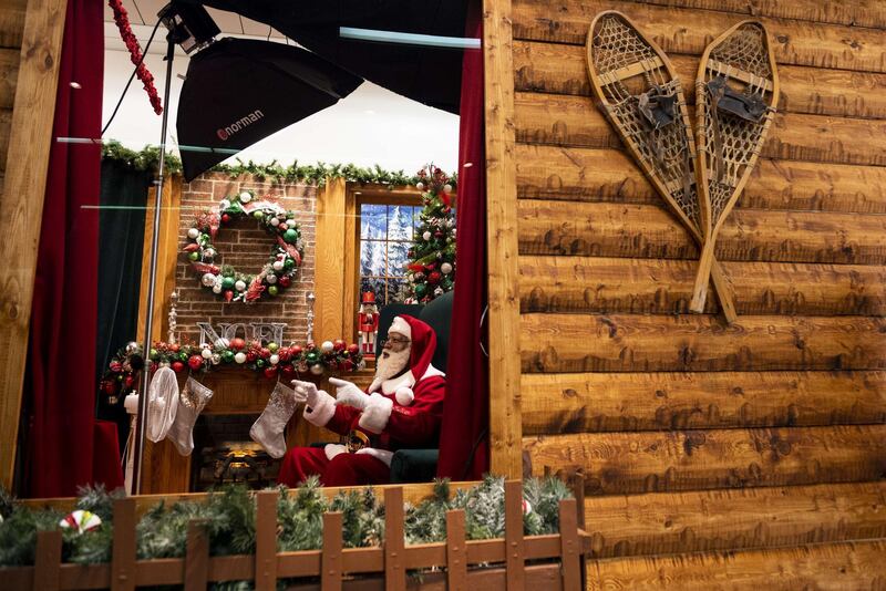 Santa Larry speaks with a virtual visitor at the Santa Experience in the Mall of America in Bloomington, Minnesota. The owners had initially set up a socially distanced set, featuring a cabin with a plexiglass window, but moved completely online after new Covid-19 restrictions were put in place. Getty Images