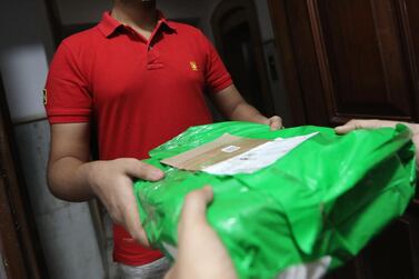 A package- is handed to a customer in New Delhi, India. Home delivery is the preferred delivery option for 85% of online shoppers during Covid-19. EPA