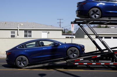 A worker unloads a Tesla Inc. Model 3 electric vehicle from a car carrier outside the company's delivery center in Marina Del Rey, California, U.S., on Saturday, Sept. 29, 2018. Tesla brought the total number of Model 3 produced in the third quarter to over 51,000 vehicles. Photographer: Patrick T. Fallon/Bloomberg