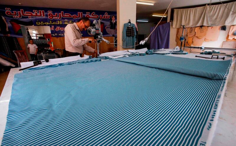 Palestinian workers operate sewing machines at a textile factory in Hebron. AFP