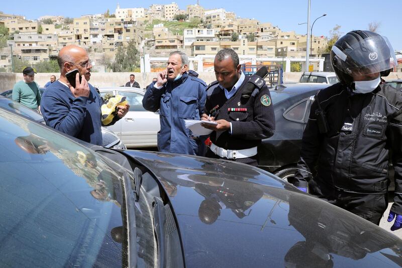 Jordanian policemen check the cars confiscated from people who violated a curfew amid concerns over the spread of the coronavirus disease (COVID-19), in Amman, Jordan April 8, 2020. REUTERS/Muhammad Hamed