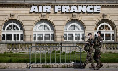 epa08408295 French soldiers wearing protective face masks walk past an Air France building in Paris,  France, 07 May 2020. France is under lockdown in an attempt to stop the widespread of the SARS-CoV-2 coronavirus causing the Covid-19 disease.  EPA/IAN LANGSDON