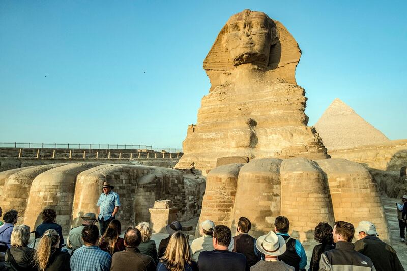 Zahi Hawass, Egyptian archaeologist and former antiquities minister, stands before the Great Sphinx of Giza during a lecture with a tourist group on ancient Egyptian history, at the Giza Necropolis on the southeastern outskirts of the capital on November 20, 2019. - The 72-year-old dubbed "the Egyptian Indiana Jones" revels in his reputation as an indefatigable yet controversial figure in the enigmatic world of Egyptology. Having appeared in dozens of documentaries about ancient Egypt, Hawass himself is a star attraction for a luxury archaeological tour organised by an operator based in Poland. He was head of Egypt's Supreme Council of Antiquities from 2002 to 2011 and then briefly minister of antiquities in early 2011, before leaving in a haze of corruption allegations along with other Mubarak allies. (Photo by Khaled DESOUKI / AFP)