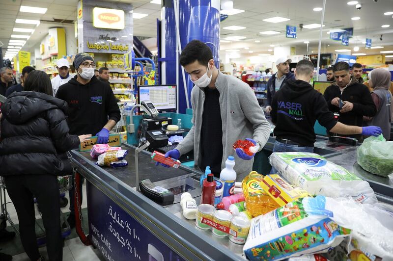 A cashier wearing a face mask and gloves amid concerns over the coronavirus (COVID-19) spread works at a mall in Amman, Jordan, March 15, 2020. REUTERS/Muhammad Hamed