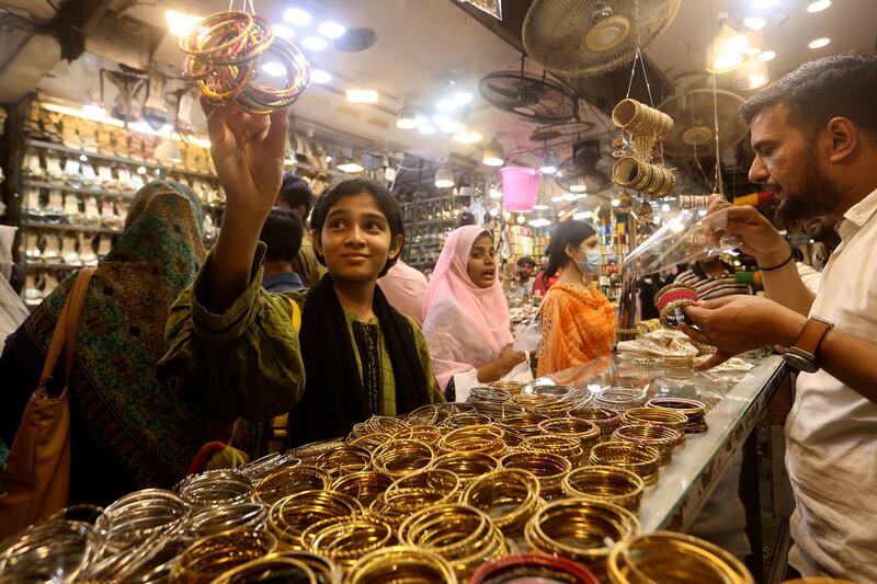 A girl looks at bangles as people shop for Eid Al Fitr in Karachi, Pakistan. AP