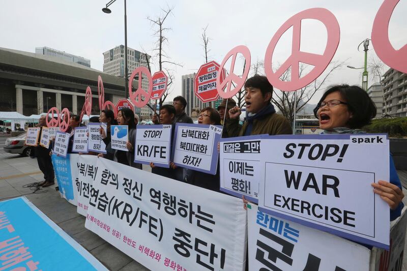 Protesters stage a rally to denounce the annual joint military exercises between South Korea and the United States near the U.S. Embassy in Seoul, South Korea, Sunday, April 1, 2018. Annual U.S.-South Korean military drills that infuriate North Korea began Sunday but they will likely be more low-key than past years ahead of two highly anticipated summits among the countries' leaders. The signs read: " We opposed the annual joint military exercises." (AP Photo/Ahn Young-joon)