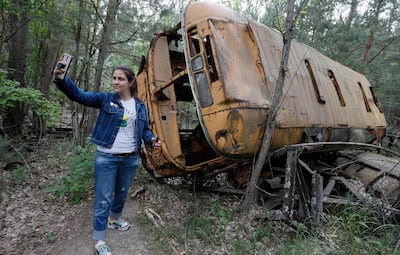 epaselect epa07633614 A visitor takes a selfie with an abandoned bus during a tour in Chernobyl, Ukraine, 07 June 2019. The miniseries Chernobyl (2019) made by HBO depicts the explosion`s aftermath, the vast clean-up operation and the subsequent inquiry. The success of a U.S. television miniseries examining the world`s worst nuclear accident has driven up the number of tourists wanting to see the plant and the ghostly abandoned town of Prypyat as local media report.  EPA/SERGEY DOLZHENKO