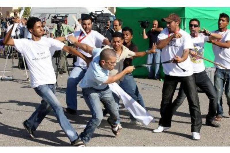 Supporters of former president Hosni Mubarak clash with an anti-Mubarak protester (centre) outside the court in Cairo yesterday. Khaled Elfiqi / EPA