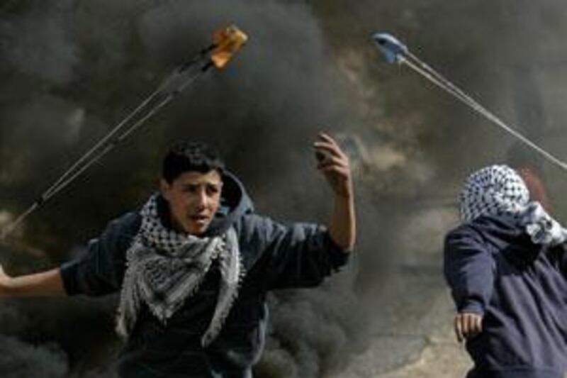 Palestinian youths use slingshots to hurl stones at Israeli soldiers during a demonstration against the military operation in Gaza, in the West Bank village of Bilin, near Ramallah, on Jan 8 2009.