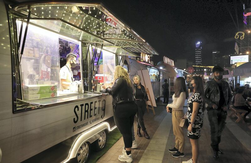 DUBAI , UNITED ARAB EMIRATES , December 18 – 2020 :- People at the Etisalat Market OTB at the Burj Park in downtown Dubai on the second day of the DSF opening concert in Dubai. ( Pawan Singh / The National ) For Arts & Culture/Online/Instagram. Story by Janice Rodrigues